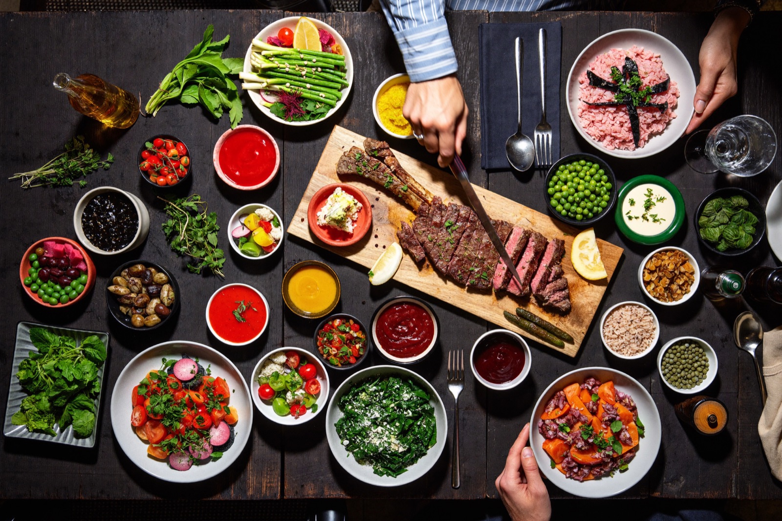 Overhead spread of fresh Latin-inspired dishes on a dark wood table